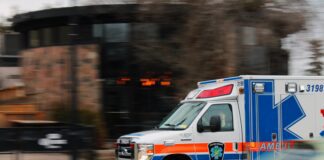 red white and blue ambulance driving to scene of emergency