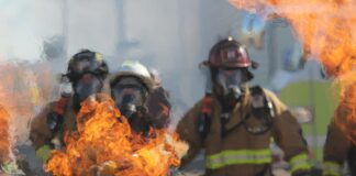 Firefighters attempt to put out vehicle fire in freeway crash